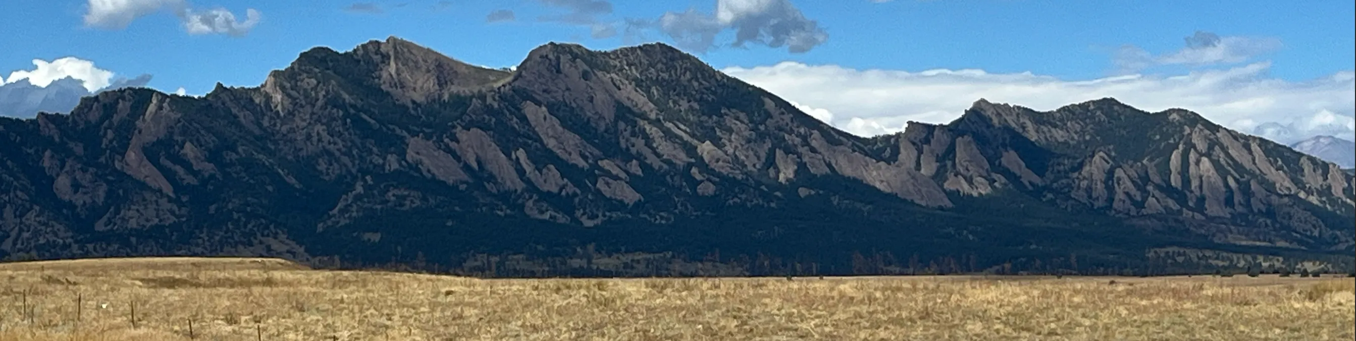 The Flatirons mountains rising above open grassland near NREL's Flatirons Campus in Colorado